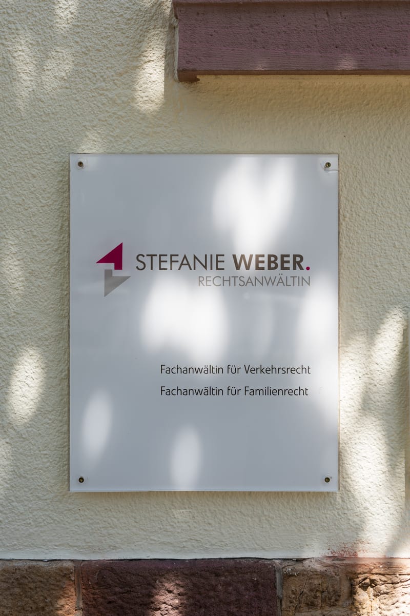 Kanzleischild mit dem Logo der Kanzlei Stefanie Weber neben dem Eingang