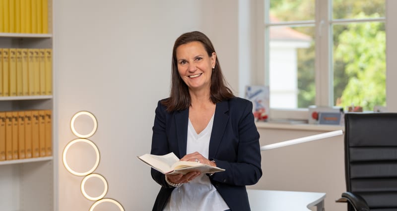 Rechtsanwältin Stefanie Weber in ihrer Kanzlei, ein aufgeschlagenes Buch in der Hand